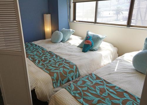two beds with pillows on them in a room at Izu no ie MOANA in Ito