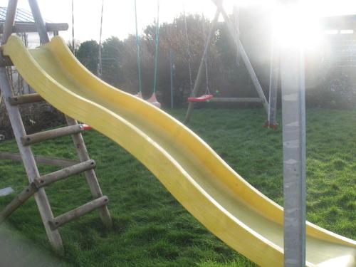 a yellow slide on a playground in a park at B&B Greenhouse 37 in Langemark