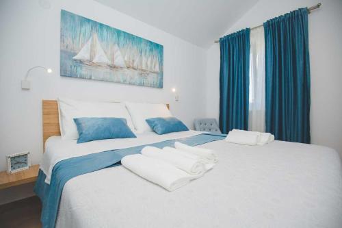 a bedroom with a large bed with two white towels on it at Salsa in Supetar