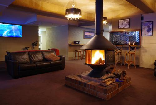 a living room with a fireplace and a couch at Matterhorn Lodge in Perisher Valley