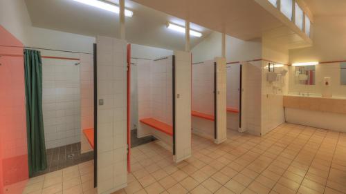 a bathroom with a row of stalls in a building at Crystal Brook Tourist Park in Doncaster East