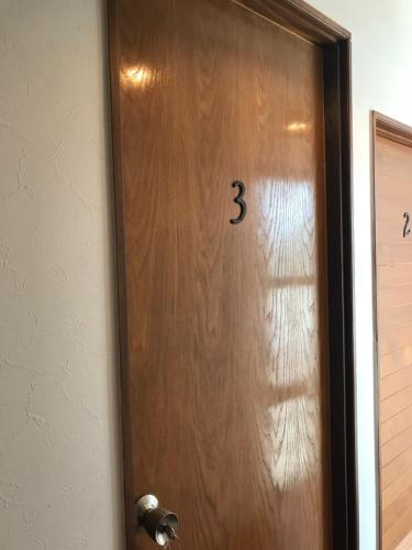 a wooden door with the number three on it at Guest House Umusan in Nago