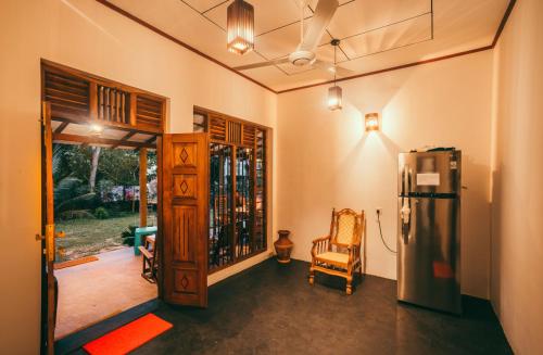 a kitchen with a refrigerator and a chair in a room at Peak House in Hiriketiya