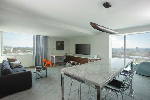 a living room with a couch and a table with a view at Andaz West Hollywood, By Hyatt in Los Angeles