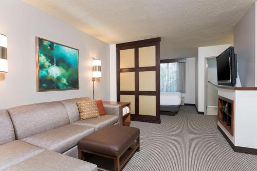 a living room with a couch and a flat screen tv at Hyatt Place Sarasota/Bradenton in Sarasota