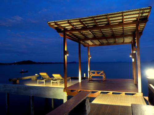 a dock with chairs and a pergola at night at Fresh House in Ko Lanta