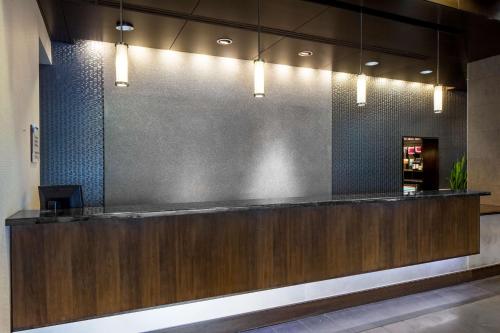 a lobby with a reception counter with lights at Hyatt House Charlotte Center City in Charlotte
