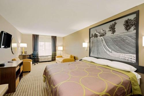 a hotel room with a large bed and a desk at Super 8 by Wyndham Lexington Hamburg Area in Lexington