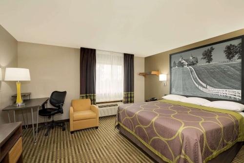 a hotel room with a bed and a desk and a chair at Super 8 by Wyndham Lexington Hamburg Area in Lexington