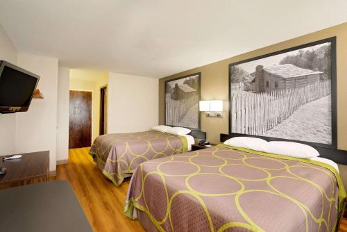 a hotel room with two beds and a flat screen tv at Super 8 by Wyndham Lexington Hamburg Area in Lexington