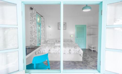 a bedroom with a bed and a blue chair at Indie Beach Bungalows in Ko Chang