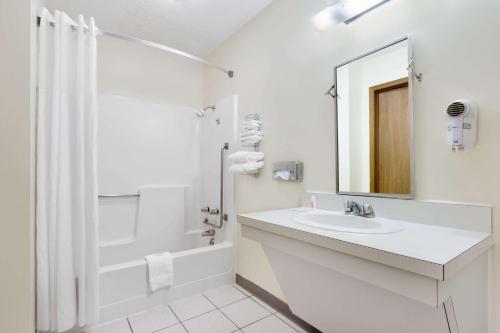 a white bathroom with a sink and a shower at Days Inn by Wyndham Concordia in Concordia