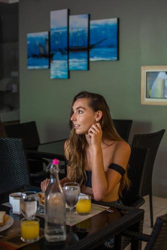 a woman sitting at a table in a restaurant at Beach Grand & Spa Premium in Hulhumale