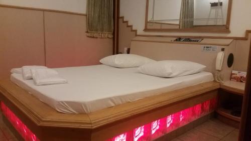 a bed in a room with red lights on it at America Motel (ADULT ONLY) in Vila Anastácio