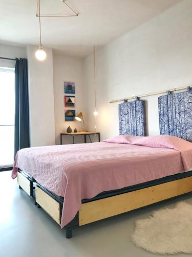 a bedroom with a large bed with a pink blanket at Cluj Apartments in Cluj-Napoca