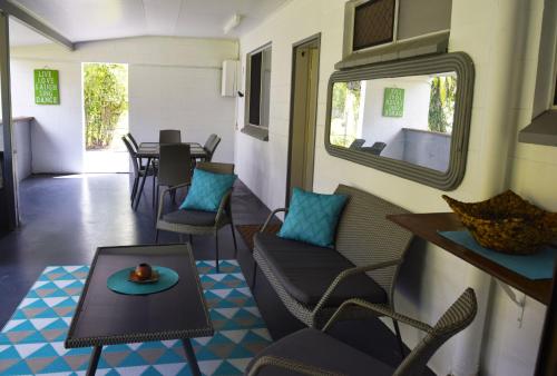a living room with chairs and a table and a mirror at Egrets Rest in Daintree