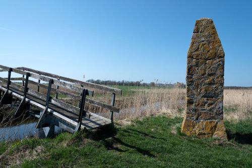 a wooden bench sitting next to a stone pillar at Haus ÜberLand in Sundhagen