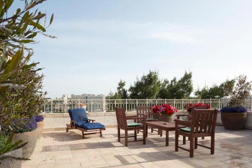 a patio with chairs and a table and chairs at The American Colony Hotel - Small Luxury Hotels of the World in Jerusalem