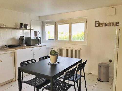 uma cozinha com uma mesa e cadeiras numa cozinha em Apartment 36 m² em Bretenière