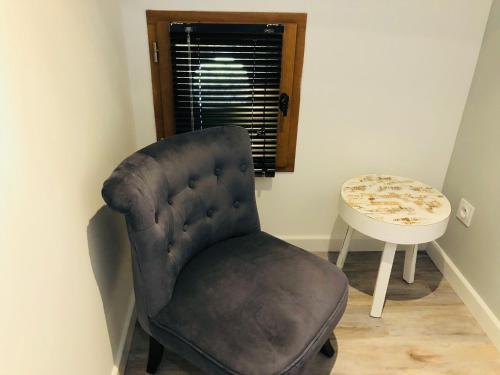 a chair and a table in a room at Appartements de Charme in Corte