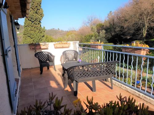 a patio with two chairs and a table on a balcony at B&B with charm, quiet, kitchen, sw pool. in Grasse