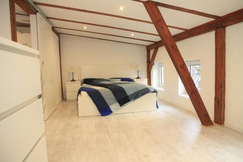 um quarto com uma cama num quarto com vigas de madeira em Gemütliche Dachgeschoßwohnung mit Altbaucharme em Lübeck