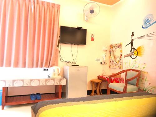 a bedroom with a crib and a tv on the wall at Nan Wan KiKi Guesthouse in Nanwan