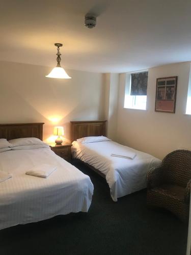 a hotel room with two beds and a chair at The Dorrington in Halstead