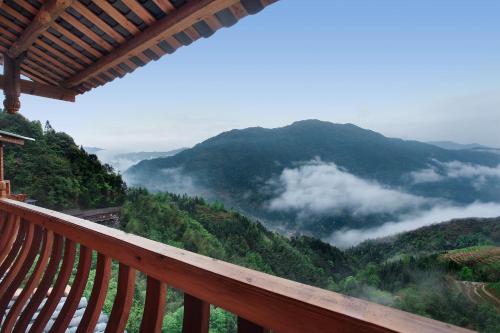 a view from a balcony of a mountain with clouds at Baike Boutique Hotel in Longsheng