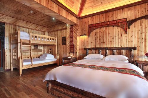 a bedroom with two bunk beds and wooden walls at Baike Boutique Hotel in Longsheng