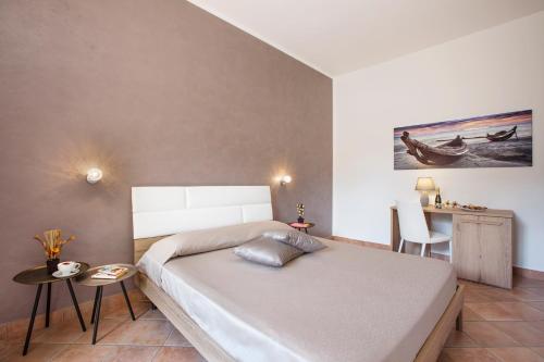 a bedroom with a bed and a table and chairs at Cala di Ponente in Castelluzzo