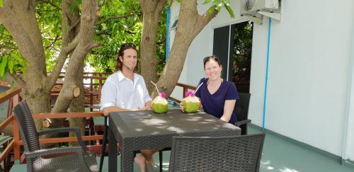 a man and a woman sitting at a table at Hulhan'gu Lodge in Himmafushi