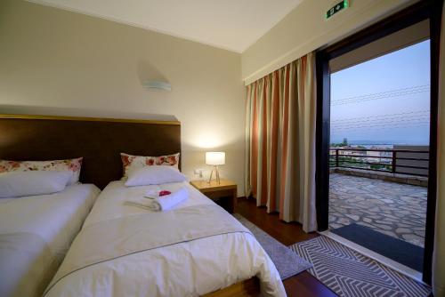 a bedroom with a bed with a view of a balcony at Althea Apartments in Katakolon