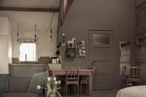 a living room with a table and a kitchen at B&B de Onlanden in Eelderwolde