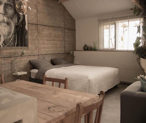 a bedroom with two beds and a table and a couch at B&B de Onlanden in Eelderwolde