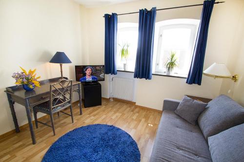 a woman sitting at a desk in a living room at Hotel Chaplin in Landskrona