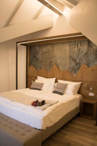 a bedroom with a large bed with a wooden headboard at Hotel Florida in Levico Terme