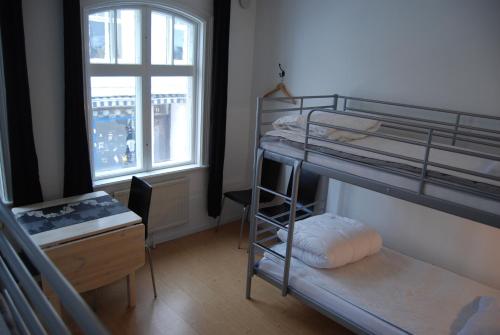 a bedroom with bunk beds and a desk and a window at Wisby Jernväg Hostel in Visby