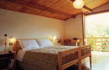a bedroom with a large bed with a wooden ceiling at Hotel Taloro in Gavoi