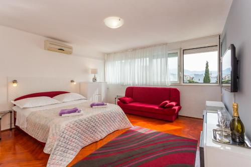 1 dormitorio con 1 cama y 1 silla roja en Beach Split Apartments, en Split