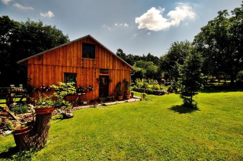 a wooden barn in a field with some plants at Na samotě U Včelína in Lančov