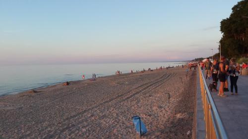 a group of people walking on the beach at Rajska Mierzeja , SAUNA , JAKUZZI ,BASEN Z PODGRZEWANĄ WODĄ , KLIMATYZACJA-OGRZEWANIE , PLAC ZABAW , ROWERY , TARAS in Sarbinowo
