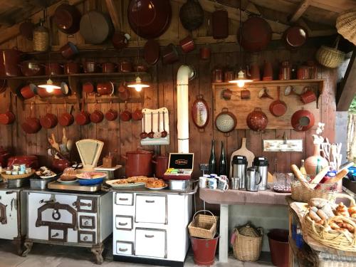 une cuisine avec des casseroles et des poêles au mur dans l'établissement Les Fermes De Pinpin, à Labaroche