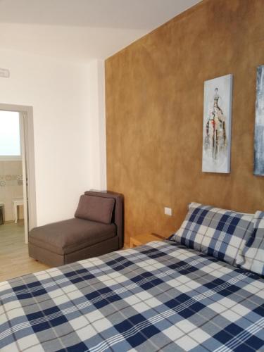 a bedroom with a bed and a chair at DAMALU' in Conversano