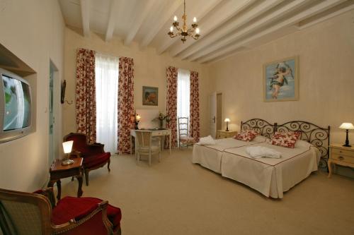 Saint-Paul-dʼEspisにあるLe Manoir Saint Jeanのベッドルーム1室(ベッド2台、椅子、テーブル付)