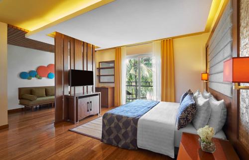 a hotel room with a bed and a television at Movenpick Resort & Spa Boracay in Boracay