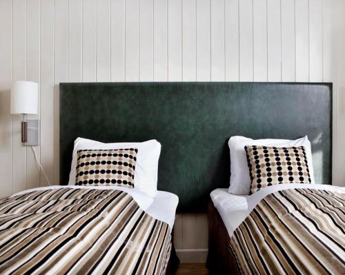 two beds sitting next to each other in a room at Søstrene Storaas hotell in Bolkesjø