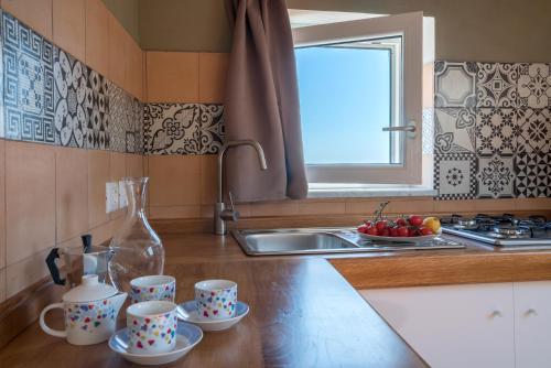 een keuken met een wastafel en drie kopjes op een aanrecht bij Plaium Montis in Salerno