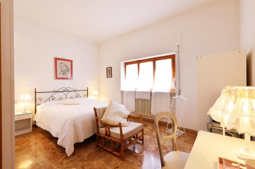 a bedroom with a bed and a chair and a window at villa oliveta in San Gimignano