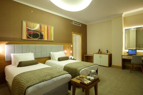 a hotel room with two beds and a table at dovsOtel in Manisa